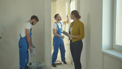 Frau geht mit Tablet spazieren und beobachtet, wie Bauherren arbeiten