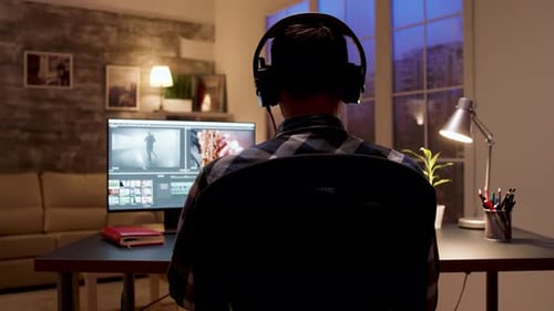 Back View of Videographer Editing a Movie Using Post Production Software
