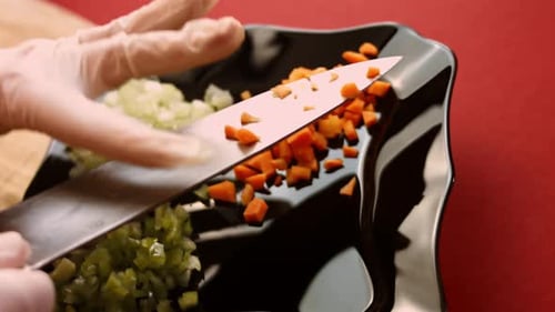 Diced Carrots Being Transferred to Black Plate