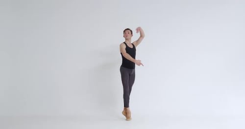 Young Man Dancer spielt akrobatische Elemente eines Balletttanzes auf weißem Hintergrund