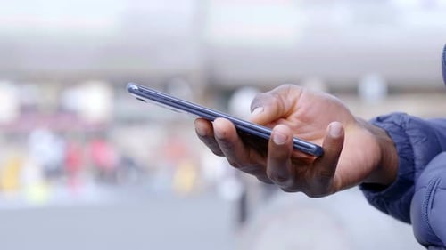 Hand Using a Phone in the City