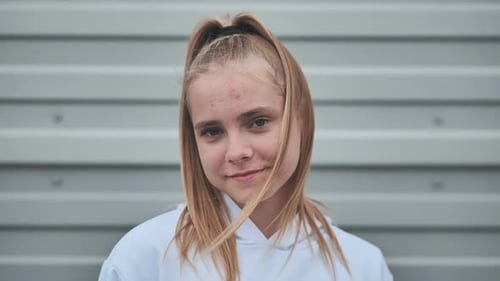 Teen Posing in Front of Gray Urban Wall