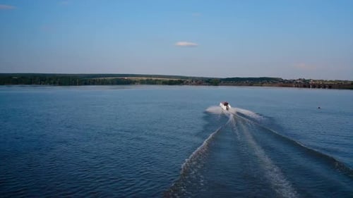 Motor boat sails along the river. Aerial view of speed boat floating on river during vacation