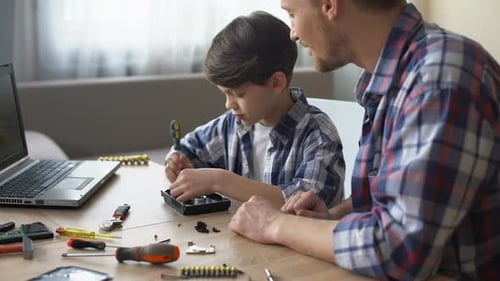Father and Son Assembling Electronics at Home Together
