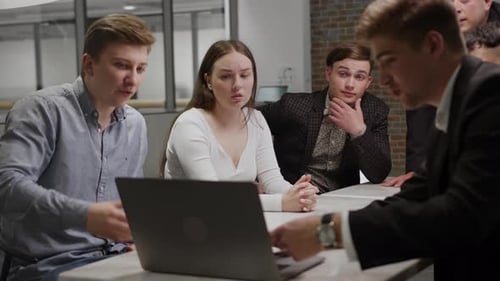 Young Adults Working Together on Laptop in Office