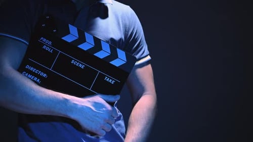Holding a Film Clapperboard in a Studio
