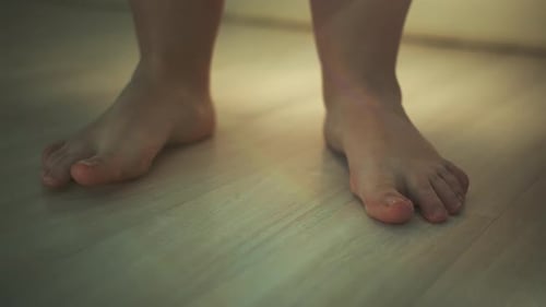 Woman's Legs on Laminate Flooring in Apartment