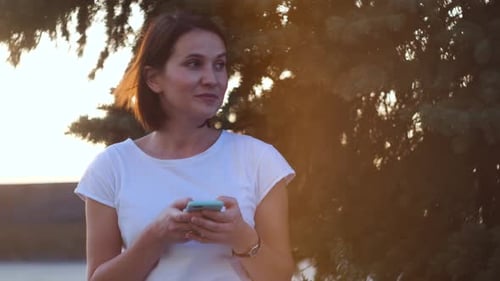 Woman Using Mobile Phone During Golden Hour