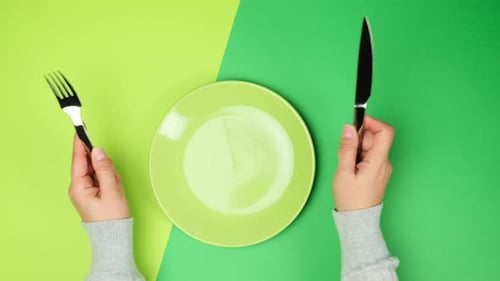 Hands Setting the Table with Knife, Fork, and Plate