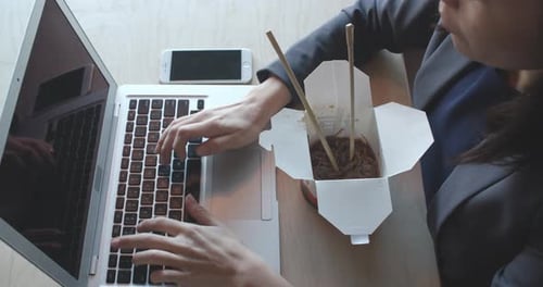 Overhead Shot of Woman Eating Lunch at Computer