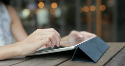 Frau benutzt Tablet-Computer im Outdoor-Café