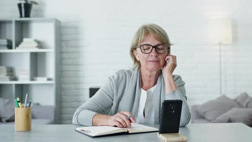 Woman on Video Call Taking Notes at Home