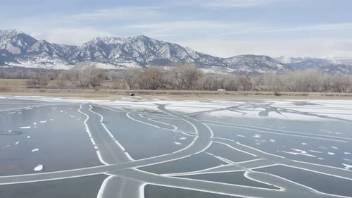 Survol aérien hivernal Cinématographique d'un lac gelé recouvert de glace vers Rocky Mountain Road, Boulder, Colorado