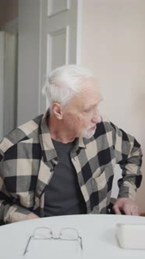 The Doctor Comes to the House of an Elderly Patient in a Wheelchair and Asks Him to Wear a Mask