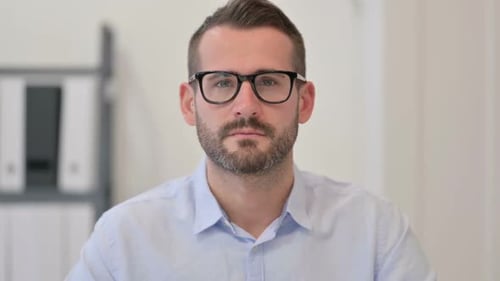 Serious Man Wearing Glasses in Office Setting