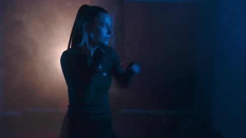 Athletic Woman Training in Blue and Orange Lighting