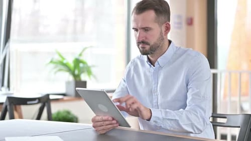 Digital Tablet Use By Attractive Young Man in Office