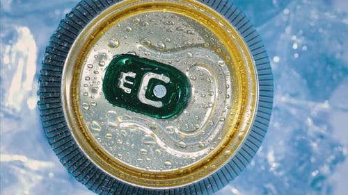 Refreshing Drink Can with Water Droplets on Ice