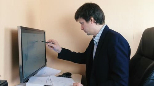 Der Mensch arbeitet an einem Computer. Vergleicht Grafiken auf dem Bildschirm und auf Papier.