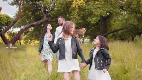 Positive Family with Two Kids Spending Summer Days at Green Garden