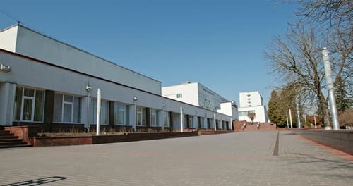 Empty City Street During Quarantine. Pan Left View of Empty Pavement and White Buildings Against