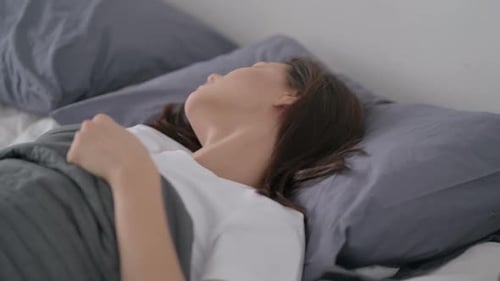 Young Woman Sleeping Peacefully in Bed