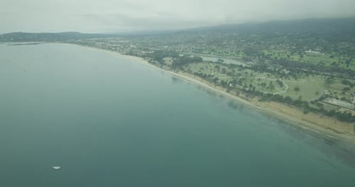 Helicopter aerial shot of foggy cityscape from the ocean, overcast day