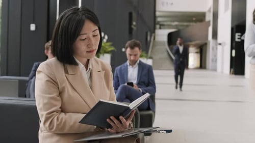 Woman Reading in Modern Office Lobby