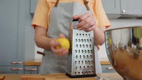 Woman Grating a Lemon in Bright Kitchen