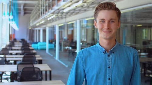 Smiling Young Adult Gives Thumbs Up in Office