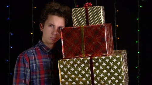 Tired Young Adult With Stack of Colorful Gifts