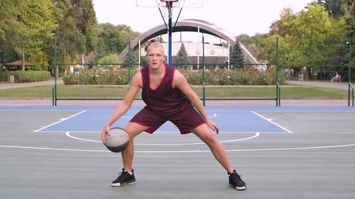 Teen Playing Basketball Dribbling Ball on Court