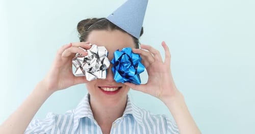 Jeune fille tenant des arcs en argent contre ses yeux