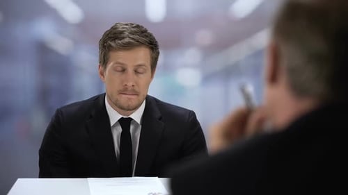 Unsicherer Mann präsentiert dem Personalmanager des Unternehmens seinen Lebenslauf, Vorstellungsgespräch