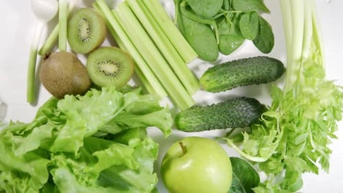 Celery Kiwi Cucumbers Green Apples and Salad on a White Plate
