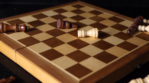Chess figures dropping in slow motion on a chess board.