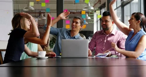 Business executive giving high five in office
