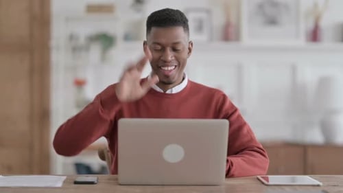African Man Talking on Video Call on Laptop in Office