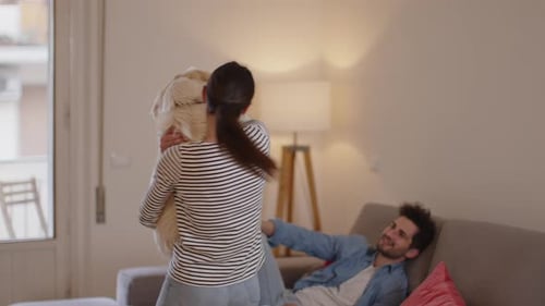 Woman Holding Dog, Man on Couch