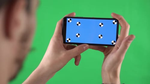 Caucasian Man Zooms By Fingers Content in Smartphone with Tracking Markers on Display on Chroma Key