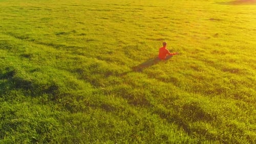 Low Altitude Radial Flight Over Sport Yoga Man at Perfect Green Grass. Sunset in Mountain