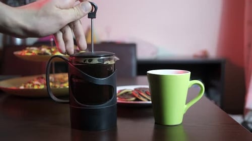 Hand Pouring Brewed Coffee into Ceramic Mug