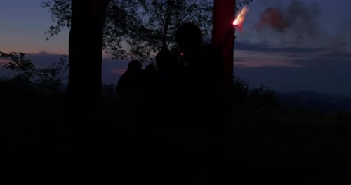 Grupo de soldados usando sinalizadores para sinalizar sua posição durante a ação militar na floresta densa
