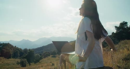 Freelance Woman Working Using Laptop Computer Outdoors with Mountain View