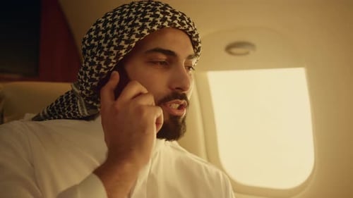 Man Talking on Phone in Airplane Cabin