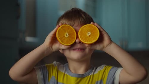 Smiling Child Having Fun With Orange Halves