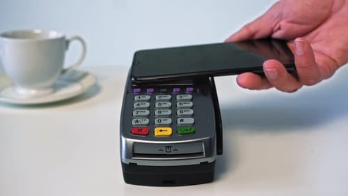 Mobile NFC Payment for Order in Cafe. Customer Paying Through Mobile Phone.