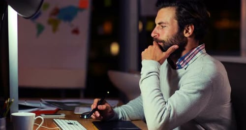 Man Working Late at Desk With Drawing Pad