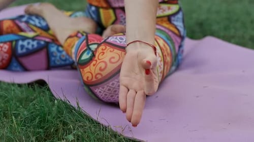 Young Woman Meditates in Lotus Pose in Park. Close-up of Hand.