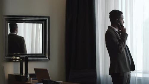 Businessman Talking on Phone in Hotel Room